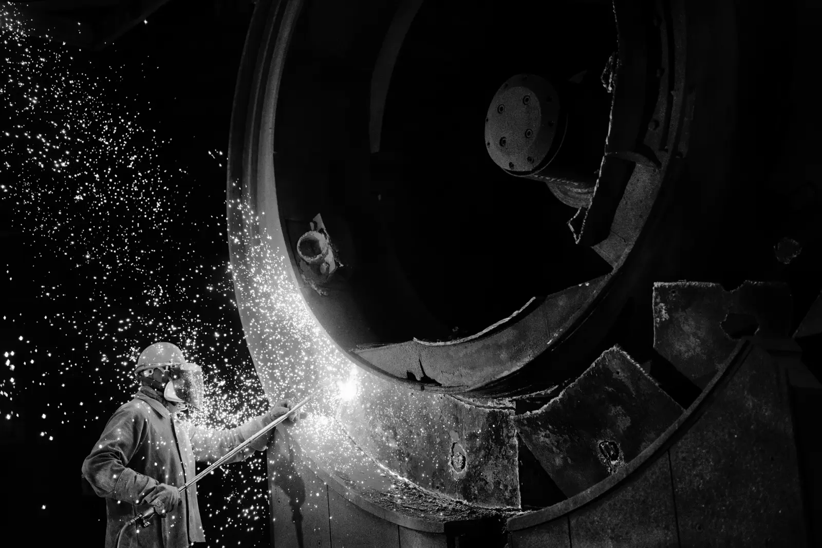 Worker using a cutting torch during the dismantling in As Pontes
